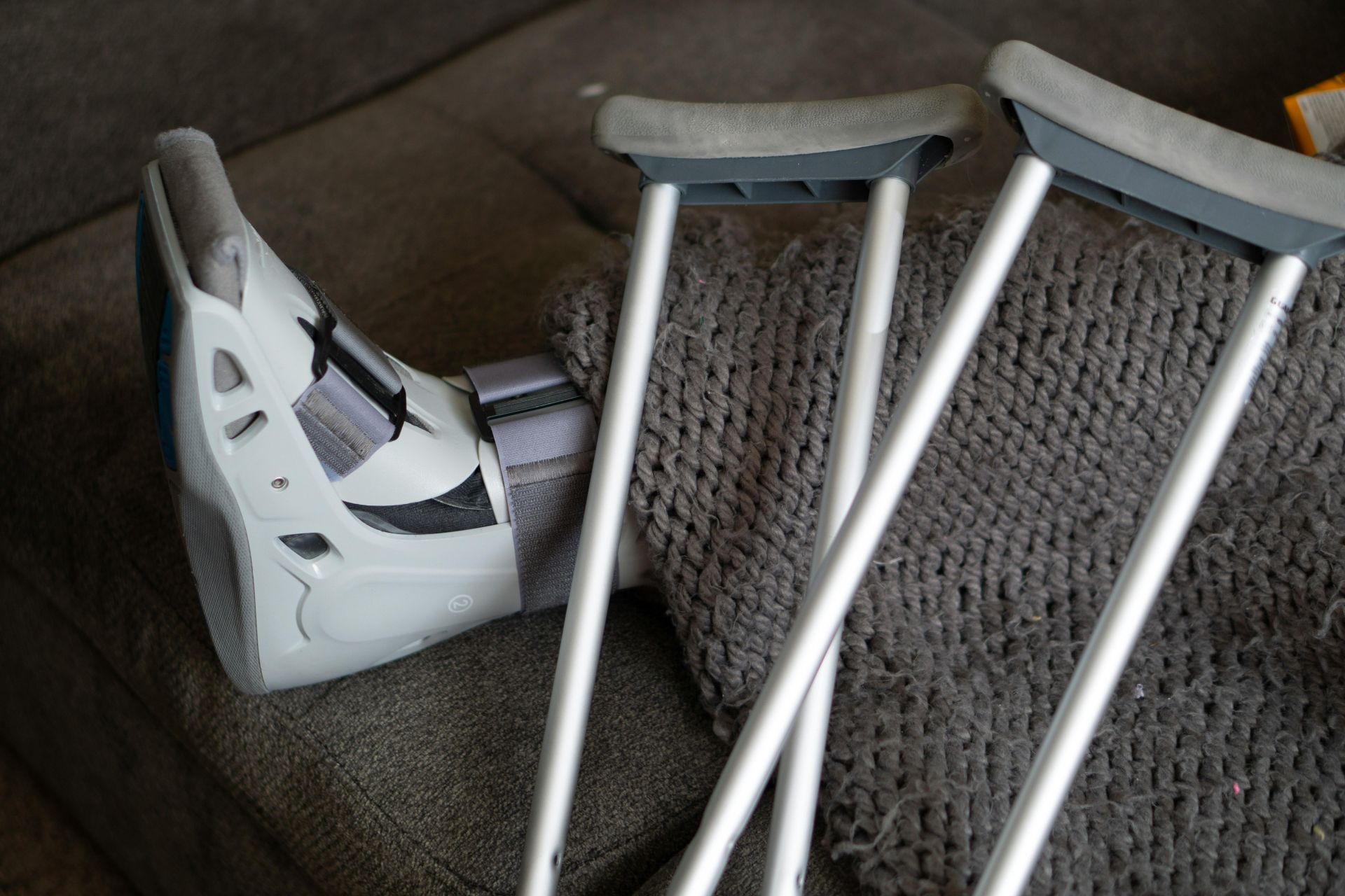 A leg in a brace on sofa with crutches