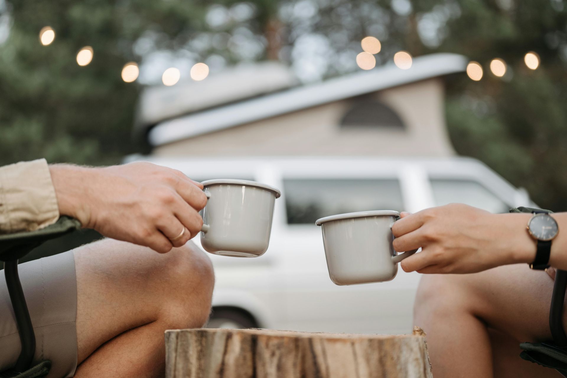 A couple camping, holding camping mugs